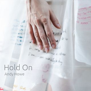 A hand on a dress with writing that you can't quite make out on the dress